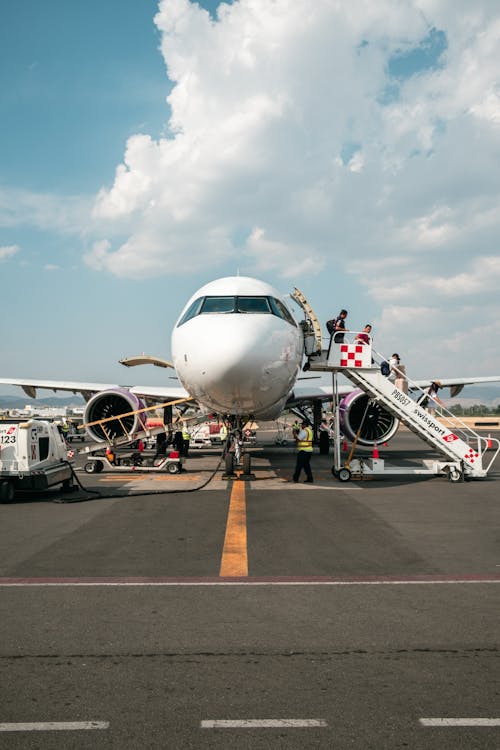 free photo of view of passengers walking out of the airplane at an airport