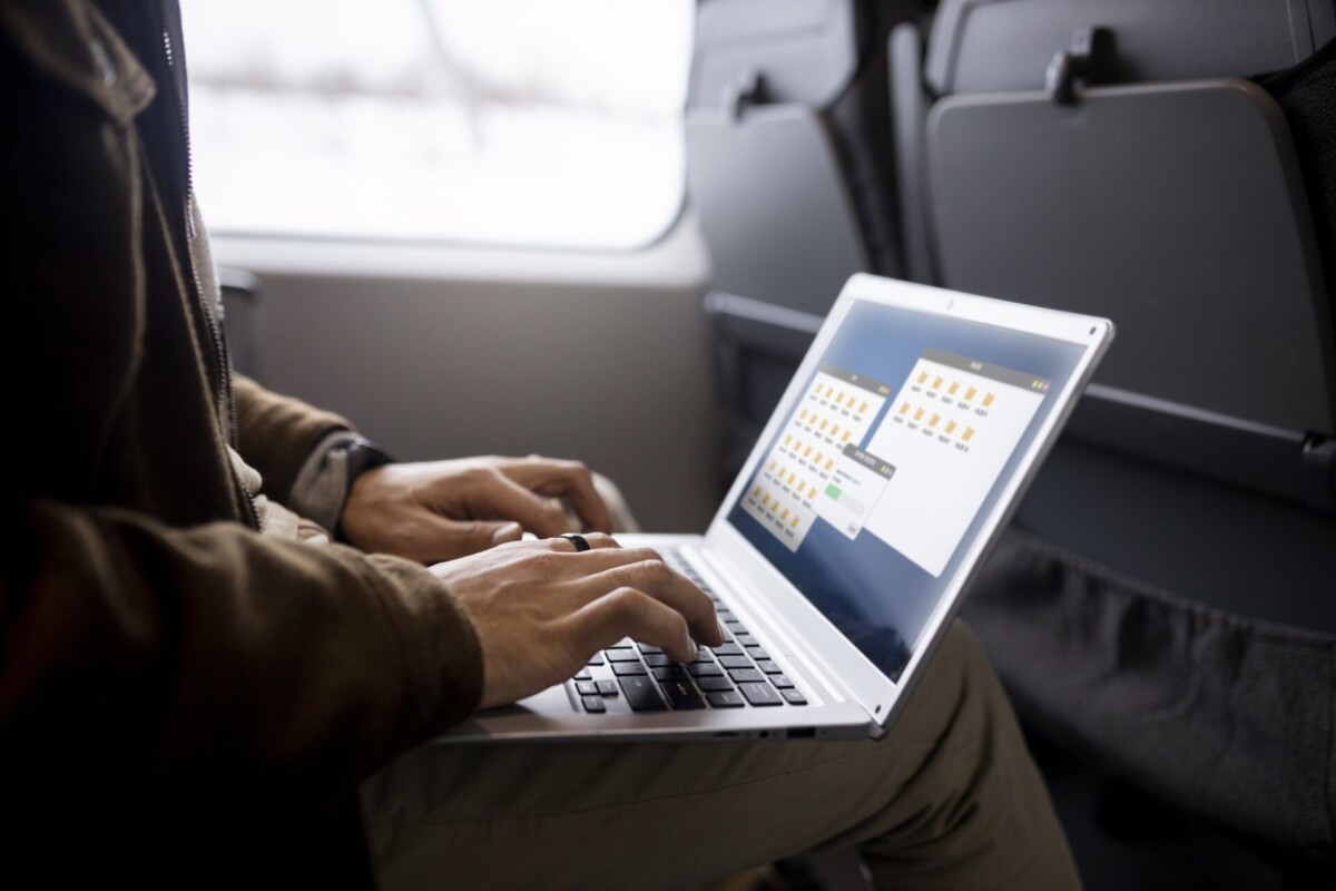 man-working-his-laptop-while-traveling-by-train