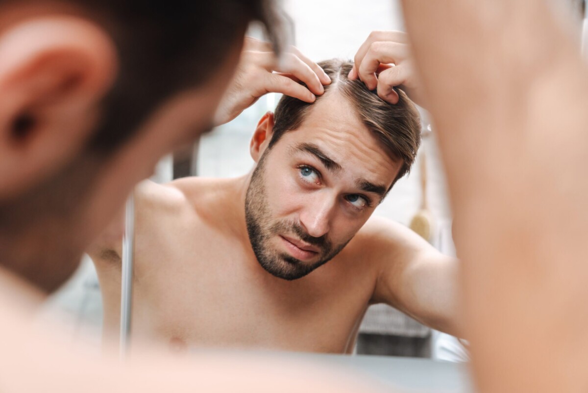 worried-young-shirtless-man-examining-his-hair-while-looking-bathroom-mirror (2)